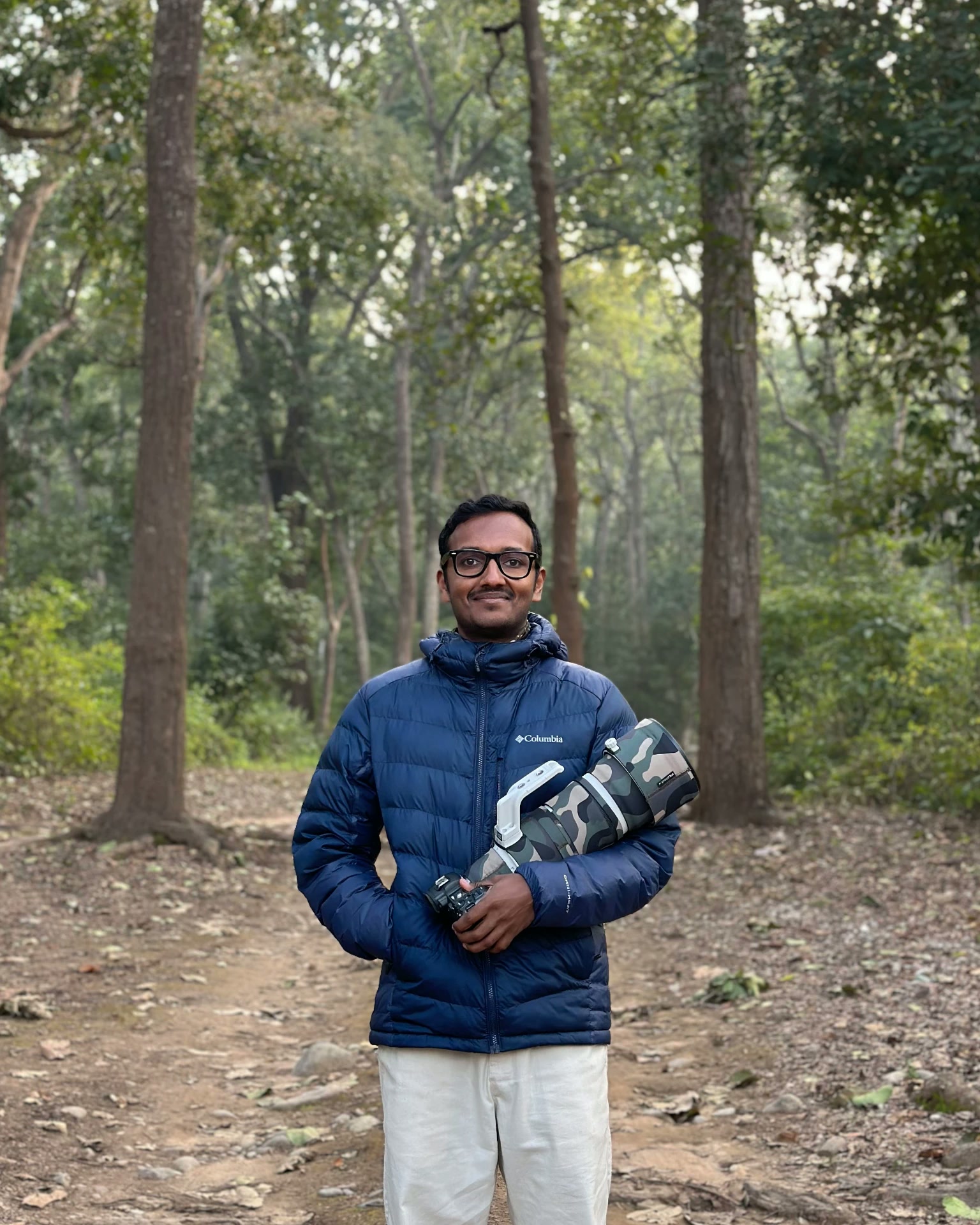 Brahmanand Kori holding a camera in a forest
